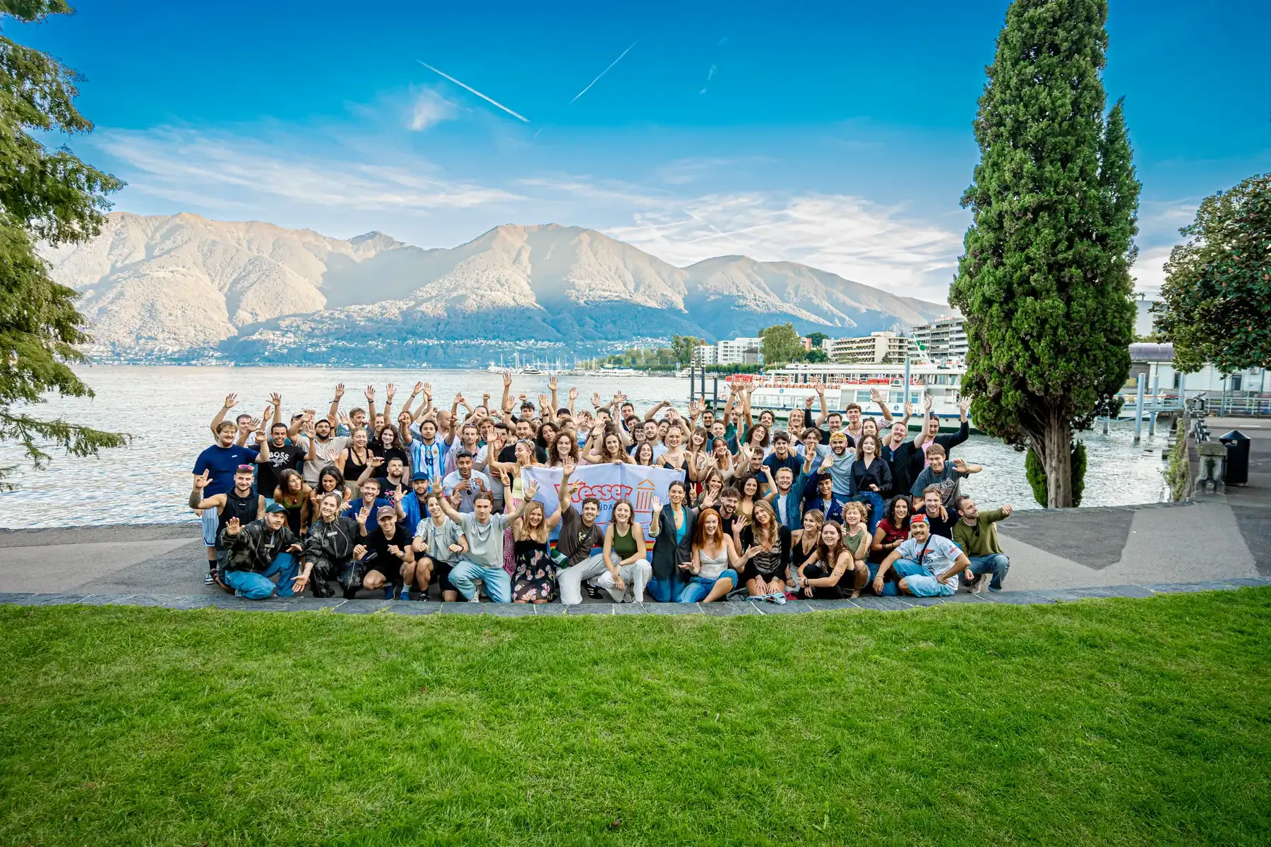 Das ganze Team beim Ausflug am Seeufer mit Bergpanorama