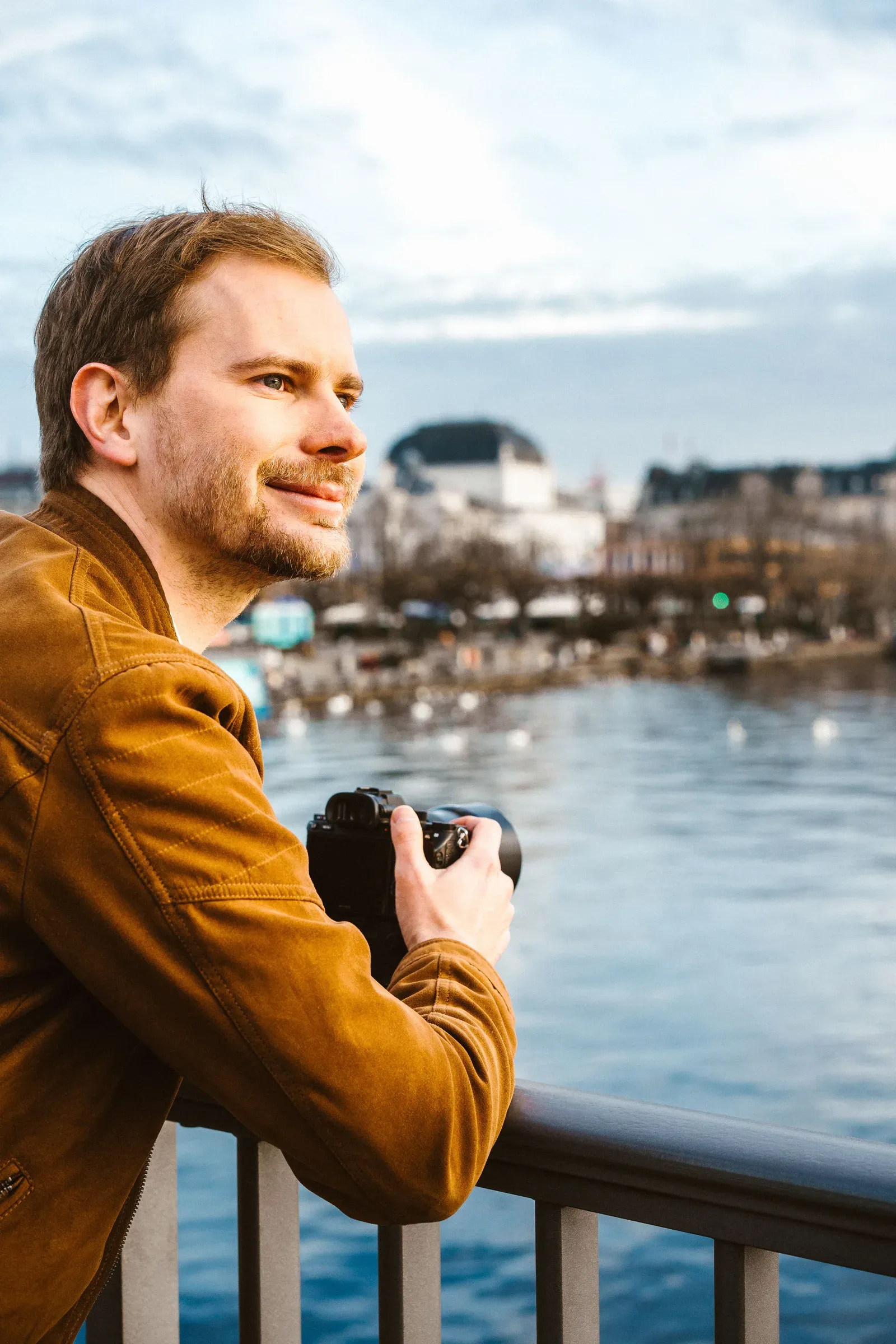 Lukas Bärlocher mit Kamera am Zürichsee, den Blick über das Wasser gerichtet