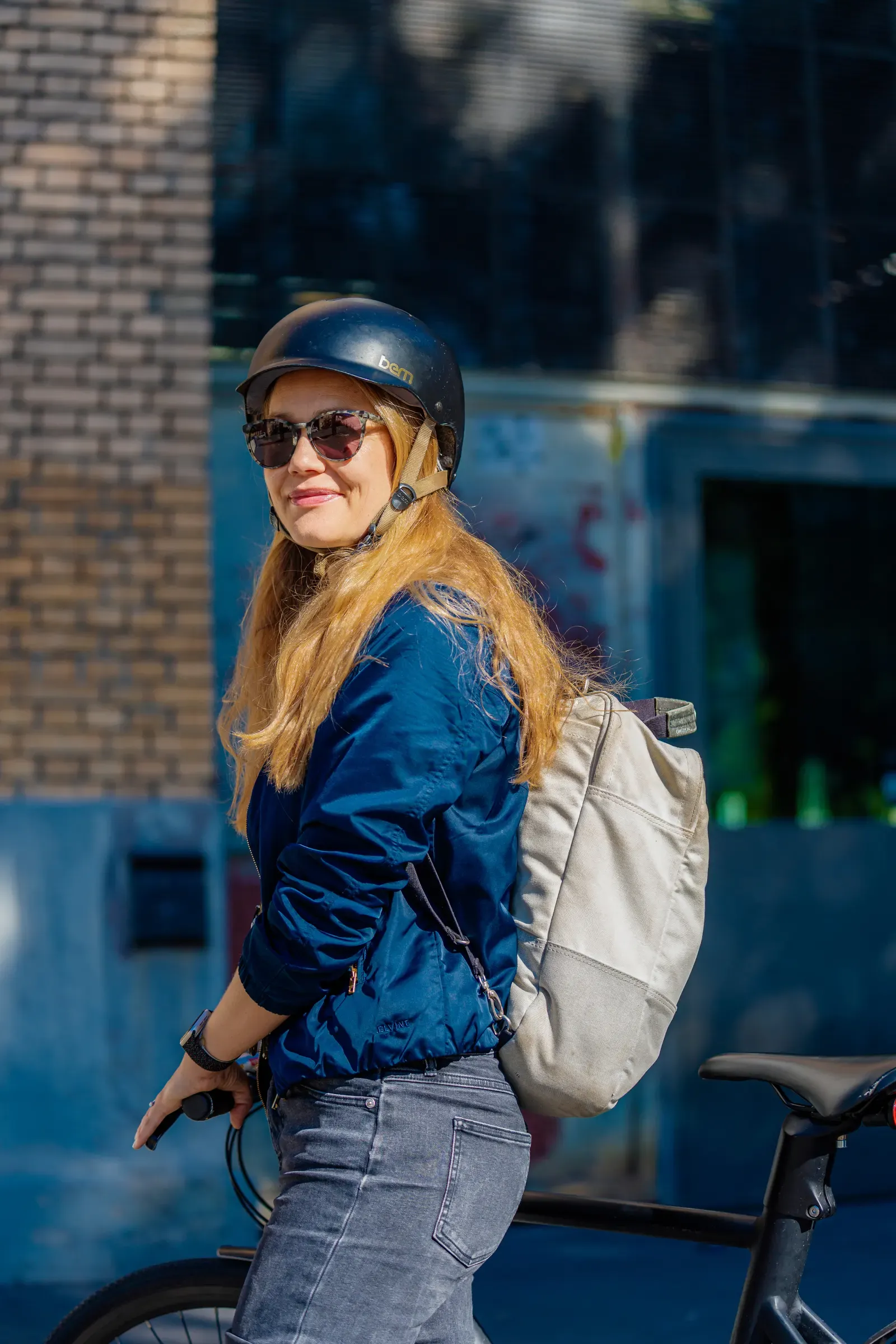 Nicola mit Velohelm und Sonnenbrille, unterwegs in der Stadt