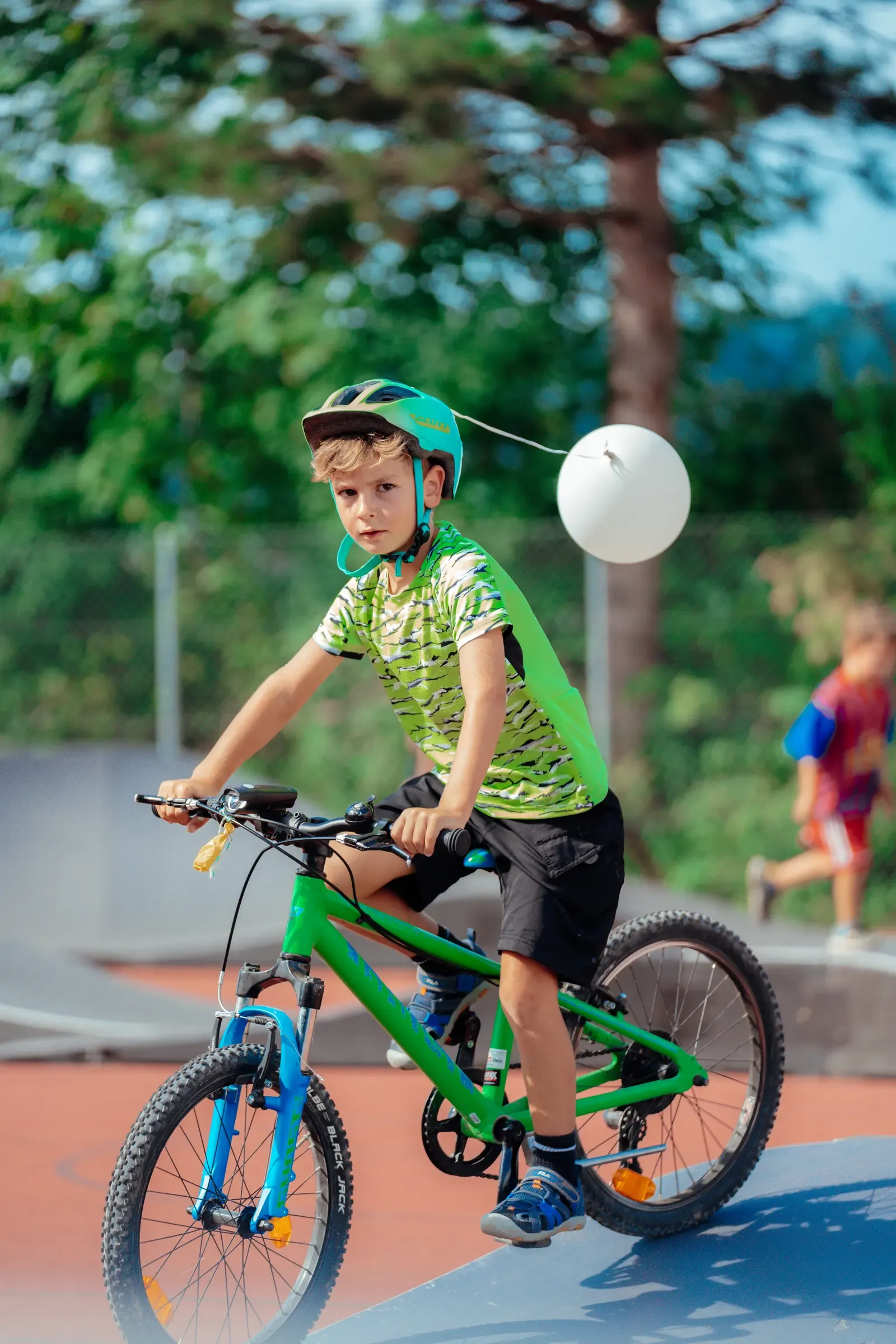 Kind im grünen Trikot auf dem Pumptrack